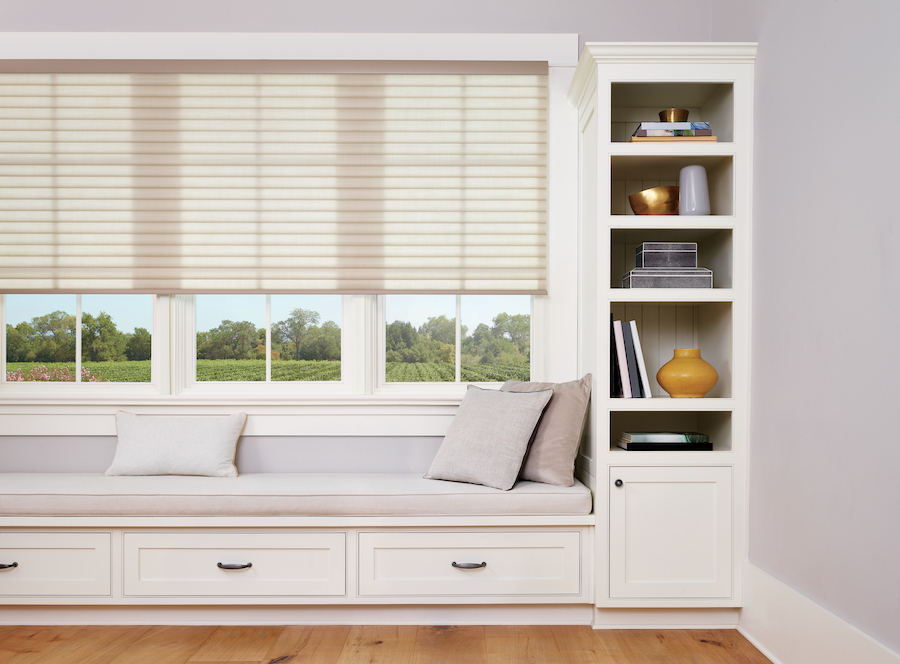 Cellular roller shades above window seat.