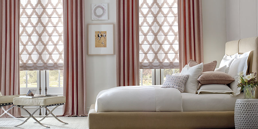 bedroom with pink curtains and patterned roller shades timan window treatments