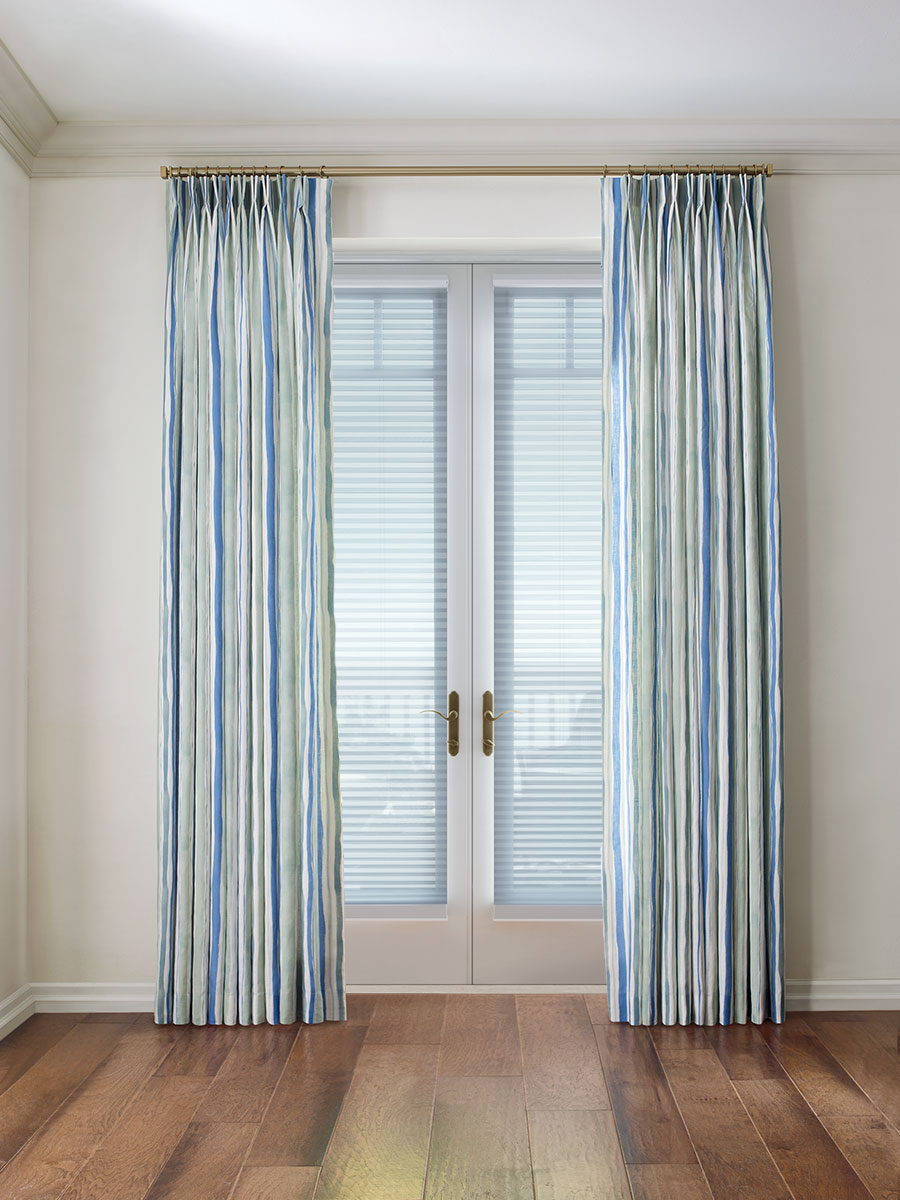 Custom door drapery with layered shades on patio doors in Cleveland home