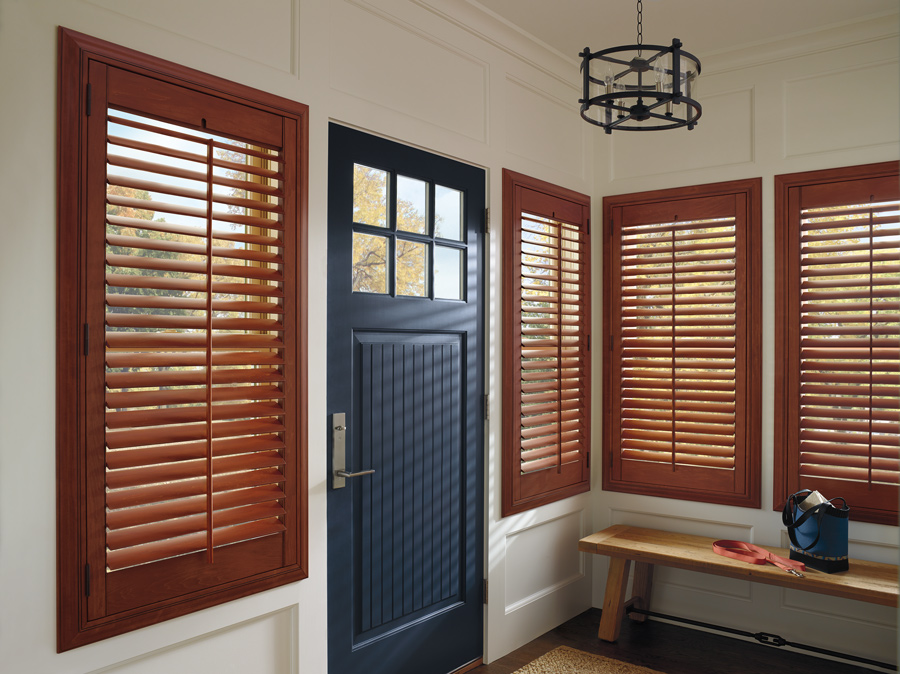 medium wood shutters on entryway windows with black door