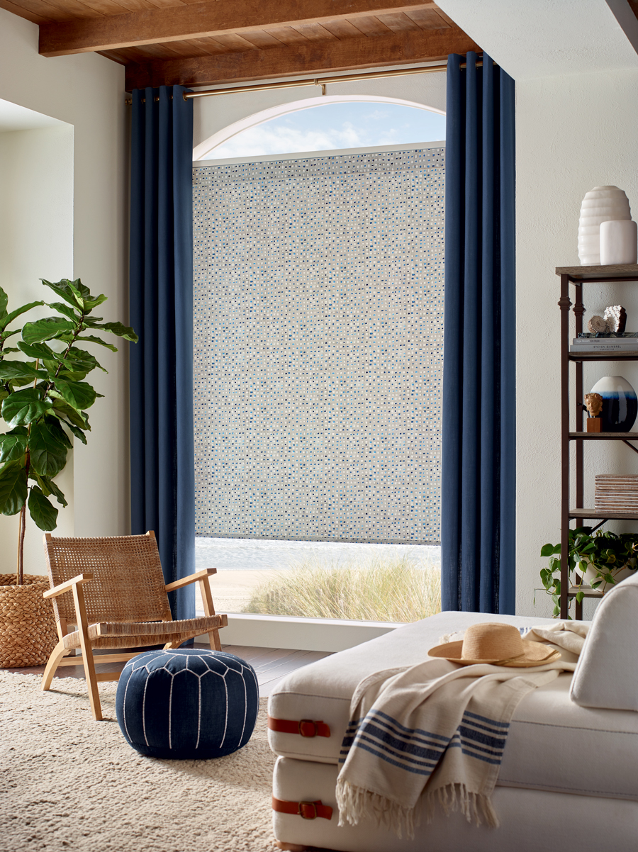 floor to ceiling curtains with patterned roller shades on uniquely-shaped windows