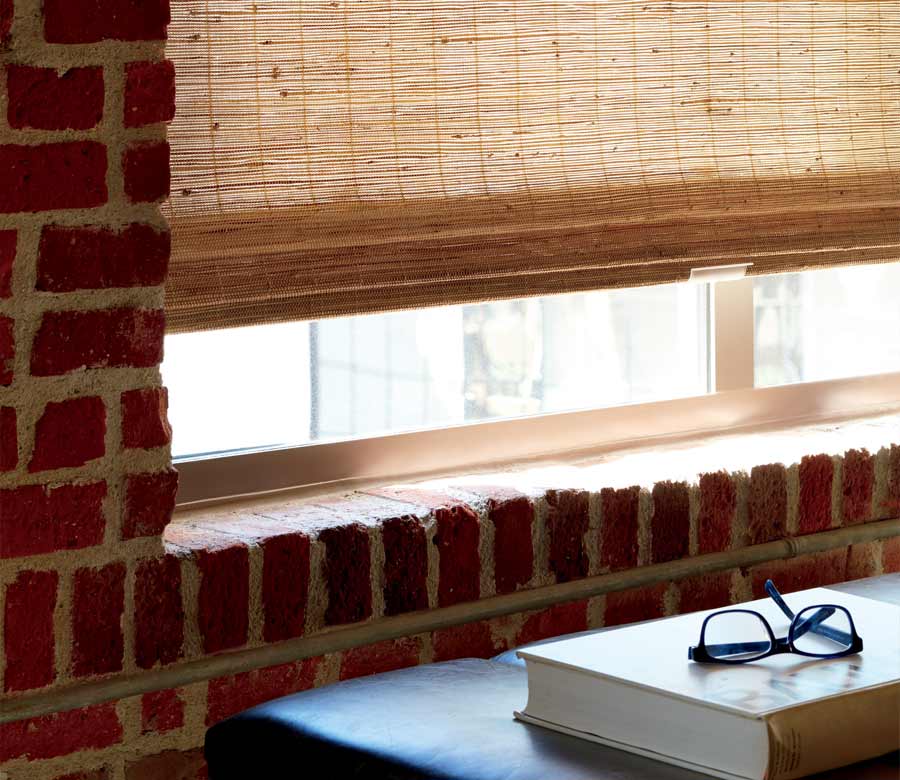 detail of custom woven shades in exposed brick apartment building