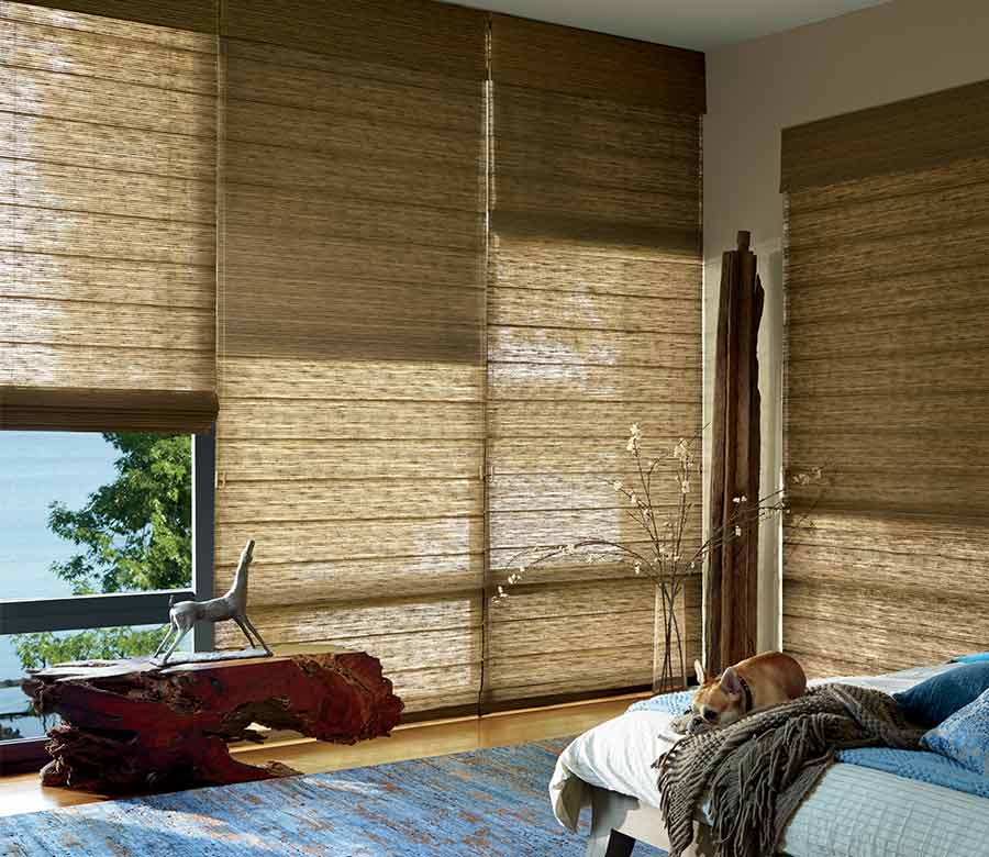 master bedroom with large floor to ceiling window treatments in caramel shades in alustra organic materials