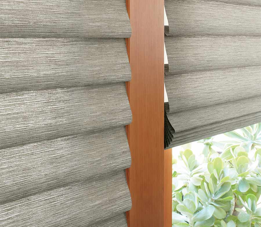 soft fabric roman shades in alustra organic materials on patio door overlooking plants