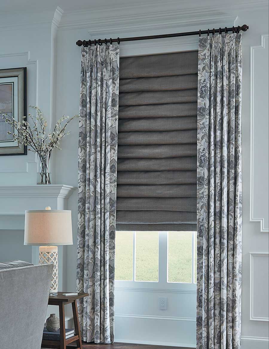 draperies and roman shades are layered fabrics at the window of Cleveland home