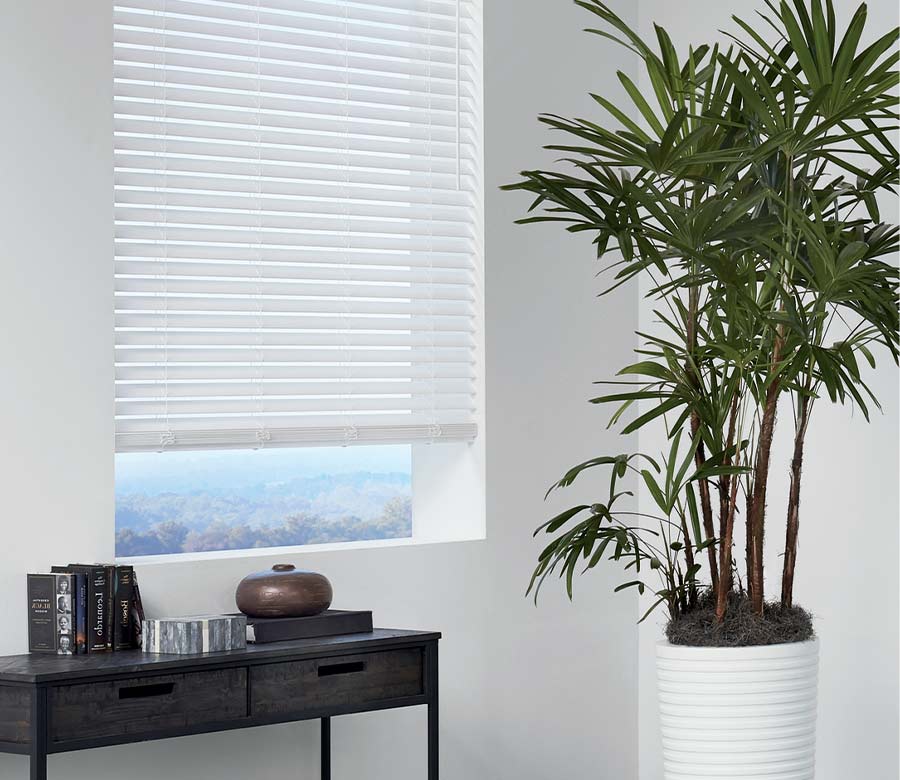white faux blinds open slightly to see the outdoors