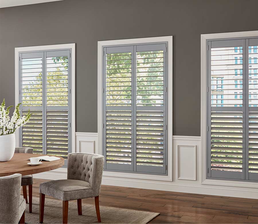 gray hardwood shutters letting light into dining room space