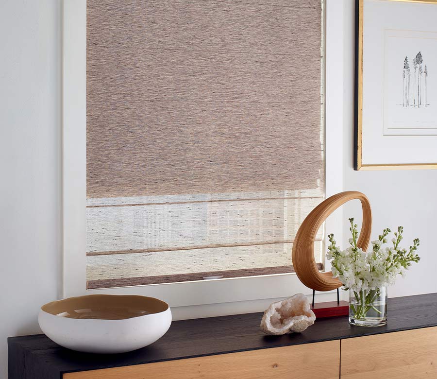 Dual shades on living room window over a black wood credenza