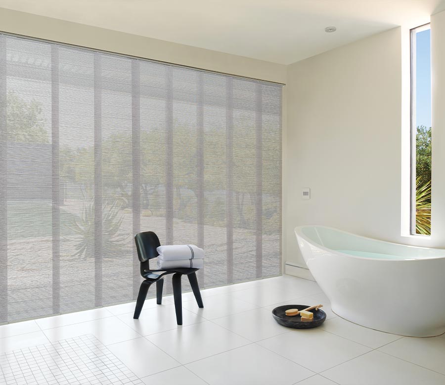 Vacation resort bathroom with floor to ceiling patio shades in gray for privacy and comfort
