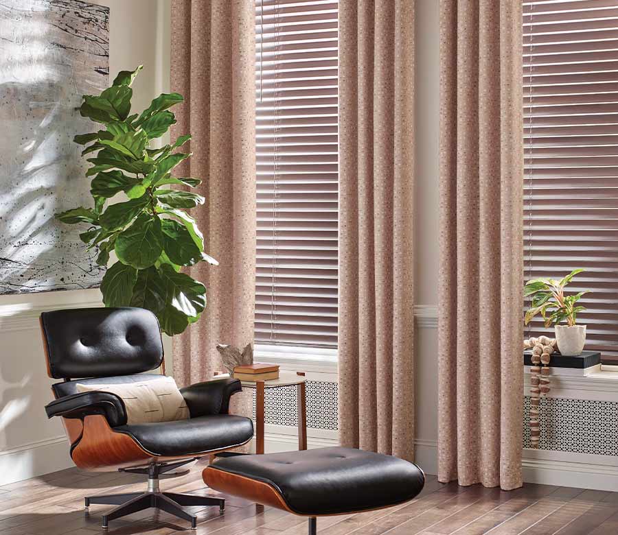 chair in corner of living room, pink floor to ceiling draperies and blinds in Pepper Pike OH home