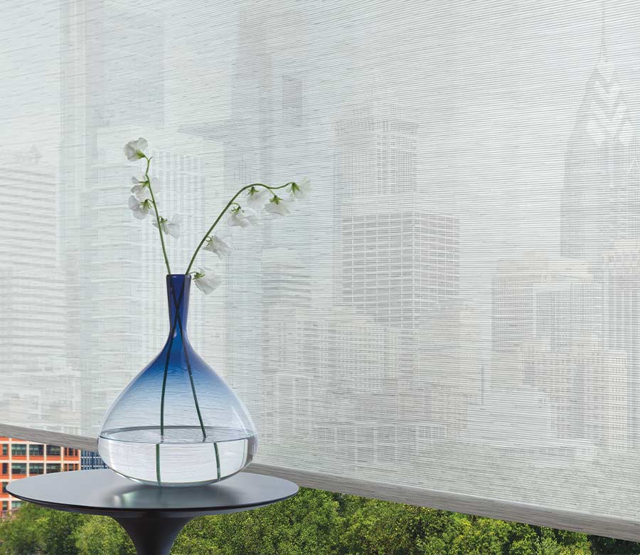 blown glass vase with blue top in front of gray screen shades in Cleveland OH