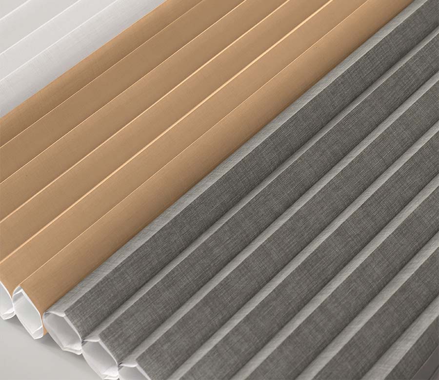 detail of different fabrics for a double cell shade in tan, gray, and white