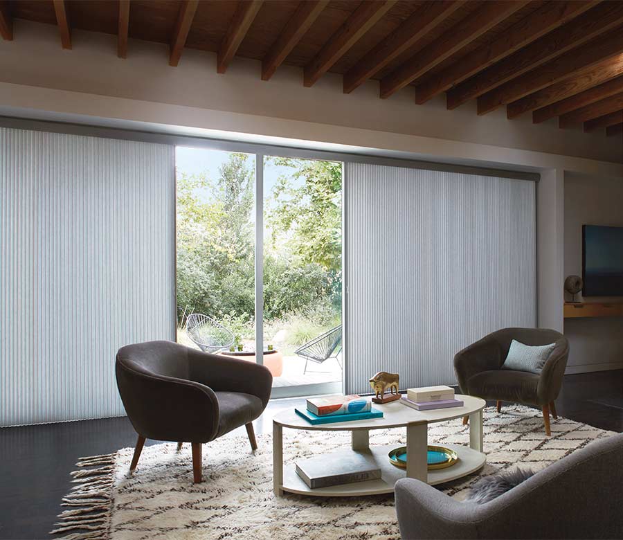 large glass sliding patio door leading to backyard seating area covered by vertical cellular shades in Chagrin Falls