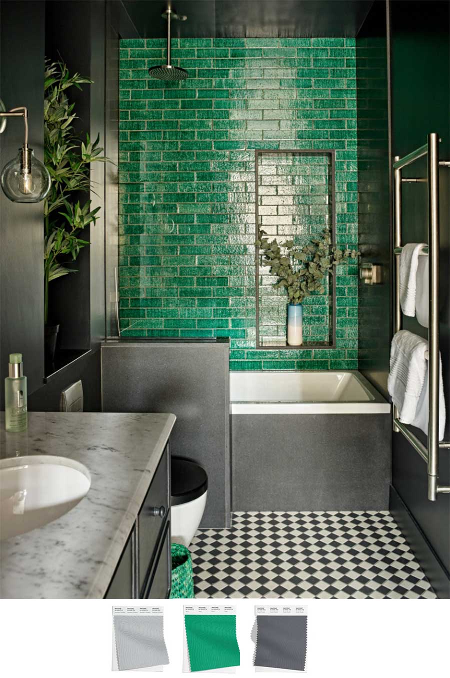 A small full bathroom with a sink to the left, toilet beyond that and a built in bathtub fitting the length of the bathroom. There are black and white small tile floorings that is paired with gray walls and a vibrant green tile that serves as a focal point once someone enters the bathroom.