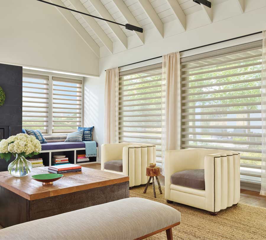 vaulted living room in Chagrin Falls with window shades and drapes on large windows