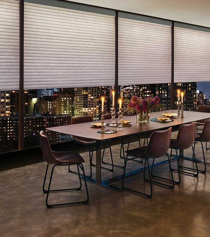 a highrise apartment dining room space with large window shades by hunter douglas