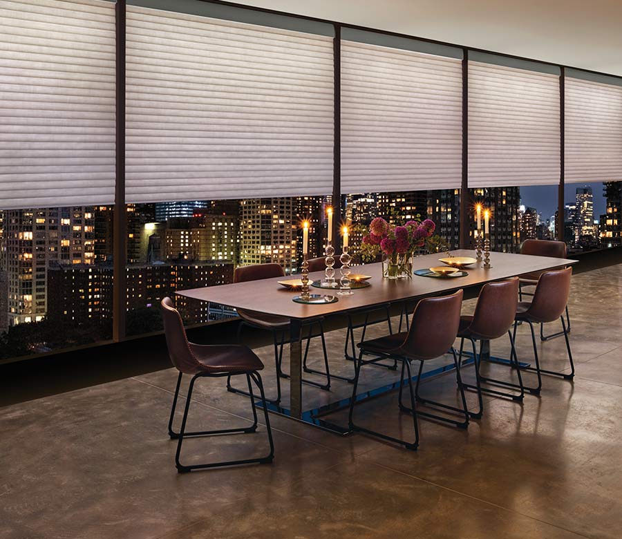 a highrise apartment dining room space with large window shades by hunter douglas