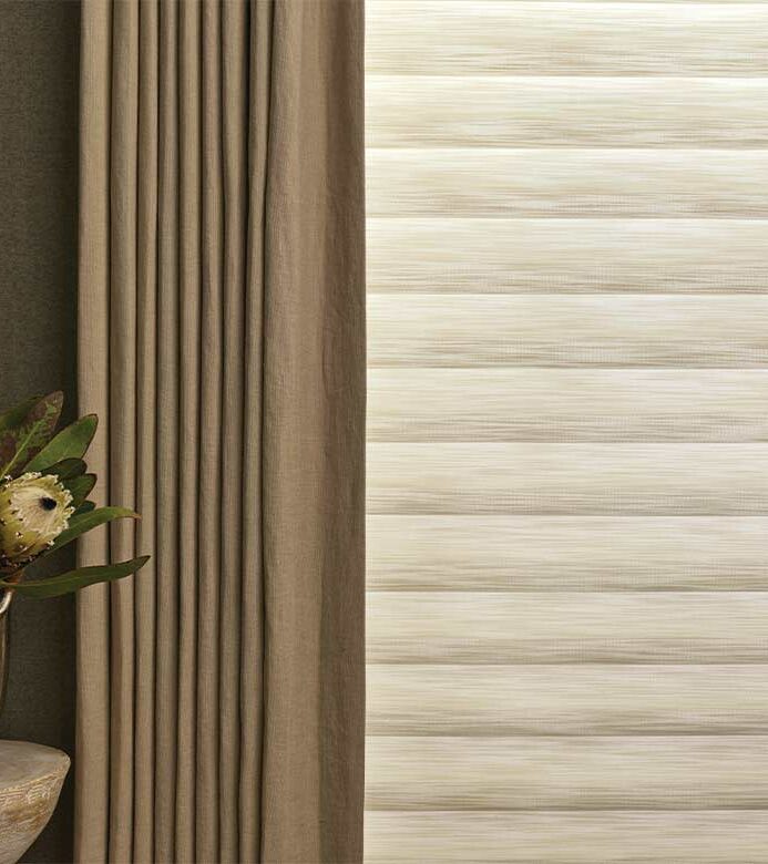 bedroom drapery layered over a roman shade in a cozy home