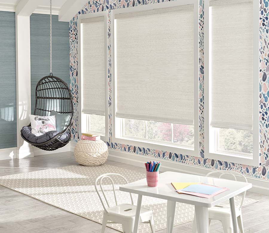 white hunter douglas shades in a natural woven wood material in kids playroom area