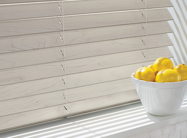 faux wood blinds in bleached wood color next to bowl of lemons