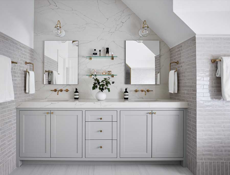 marble accent wall in primary bathroom with roof slope