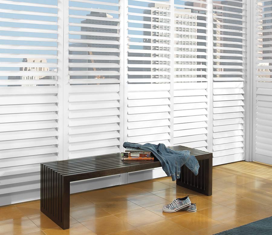 floor to ceiling white plantation shutters overlooking city skyline