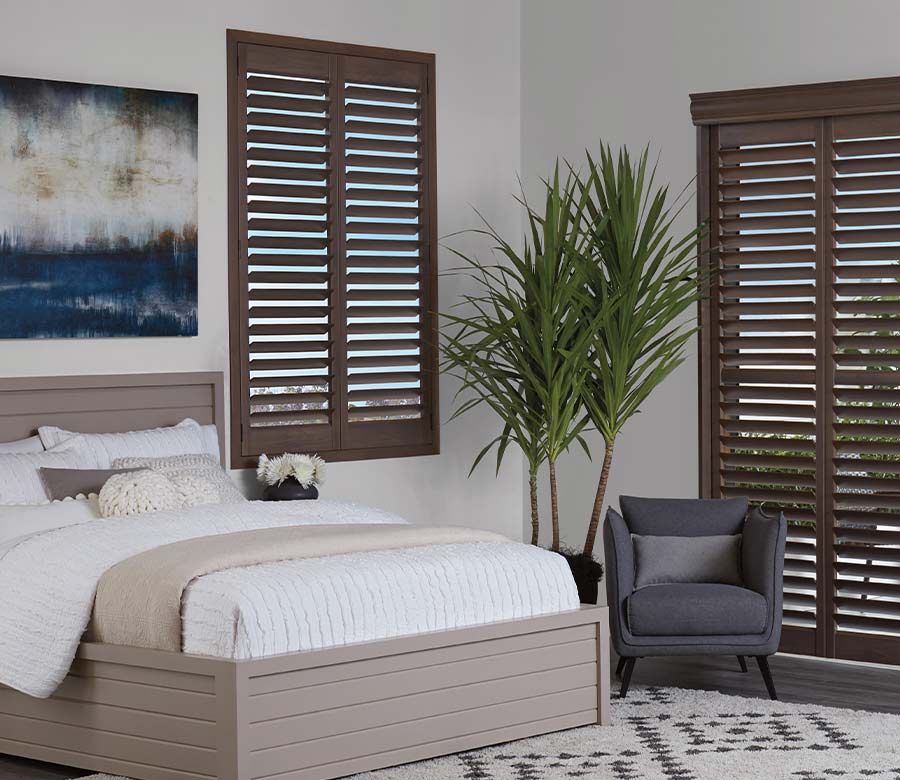 guest bedroom brown shutters and coastal setting
