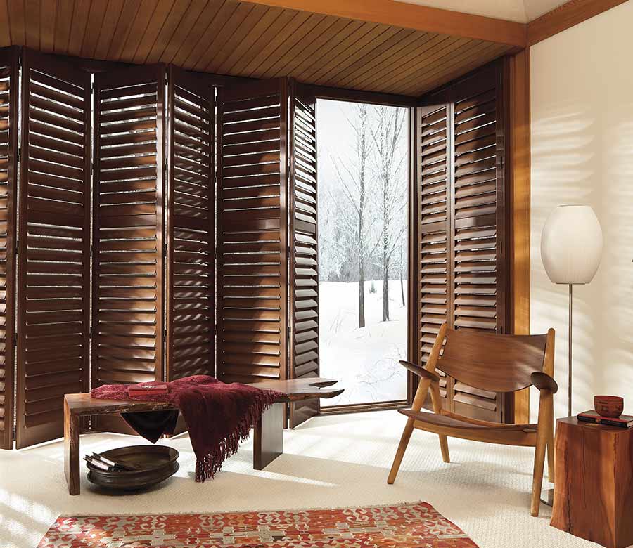 bifold tracking shutters floor to ceiling in stained brown wood color
