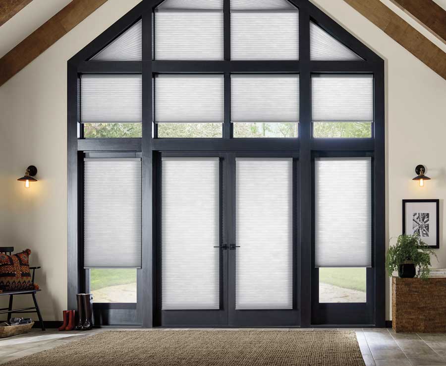 Applause® Honeycomb Shades covering a peaked black trim set of windows