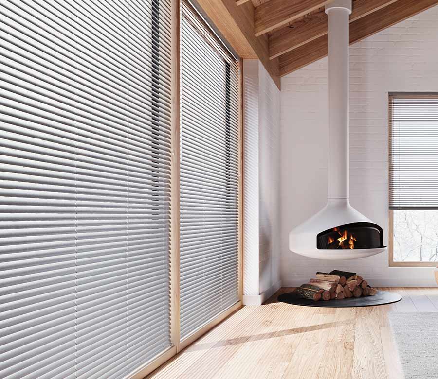 aluminum blinds on floor to ceiling windows in home with vaulted ceiling